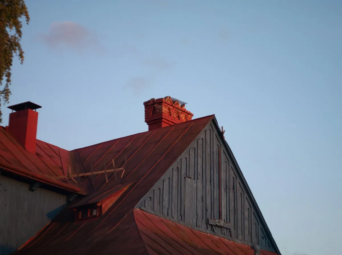 Historic Roof Replacement in Glendale — a red brick chimney on a red metal roof